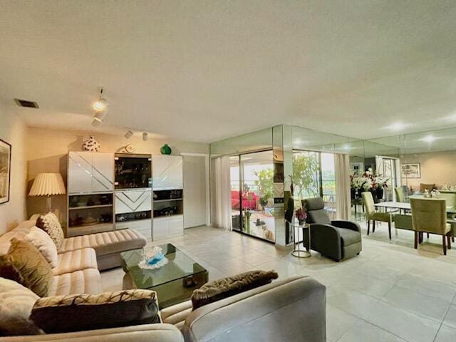 living room featuring light tile patterned flooring and visible vents