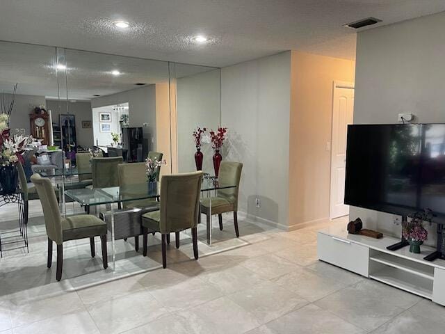 dining area featuring recessed lighting, a textured ceiling, and visible vents