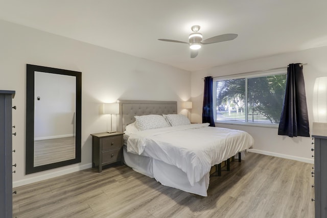 bedroom featuring a ceiling fan, light wood-type flooring, and baseboards