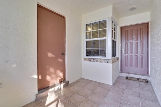 entrance to property featuring stucco siding