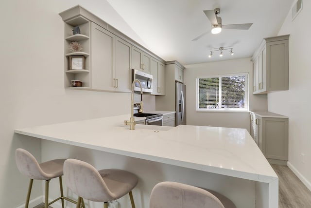 kitchen with gray cabinets, appliances with stainless steel finishes, a peninsula, and open shelves