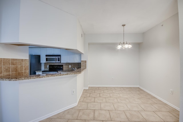 kitchen with electric range, stainless steel microwave, freestanding refrigerator, blue cabinets, and light stone counters