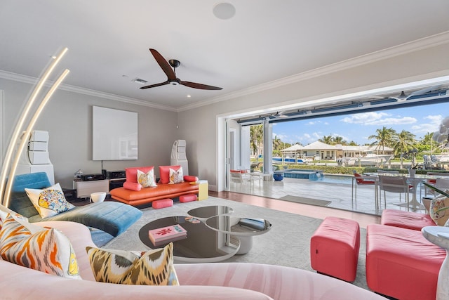 living area with crown molding, wood finished floors, visible vents, and ceiling fan