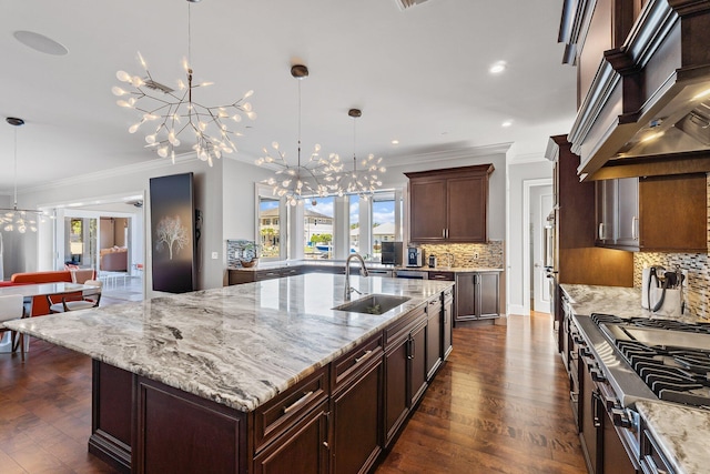 kitchen featuring tasteful backsplash, custom range hood, an inviting chandelier, dark wood-style floors, and a sink