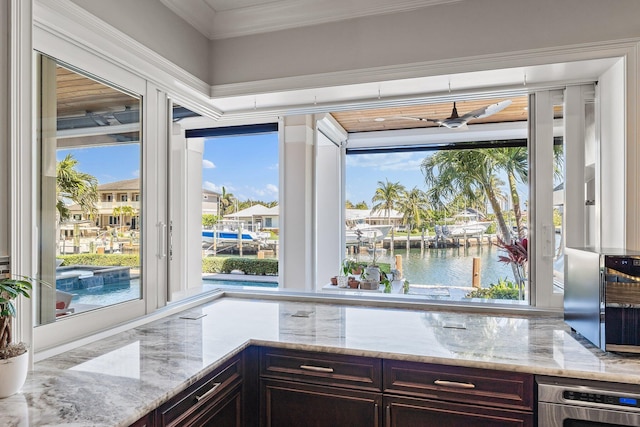 kitchen featuring stainless steel oven, light stone counters, and dark brown cabinetry