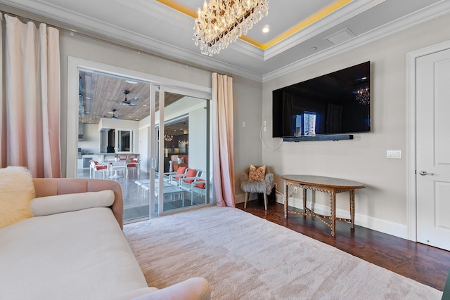 living room featuring a notable chandelier, ornamental molding, wood finished floors, recessed lighting, and baseboards