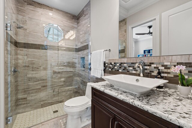full bathroom featuring a stall shower, vanity, a ceiling fan, and ornamental molding