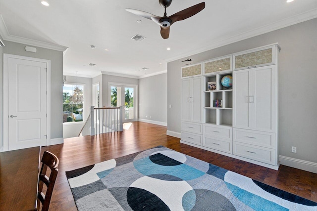 sitting room with dark wood-style floors, an upstairs landing, visible vents, and ornamental molding