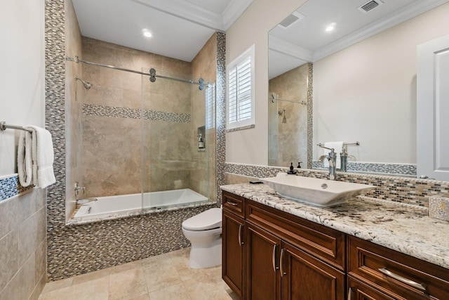 full bath with visible vents, toilet, tiled shower / bath, and crown molding