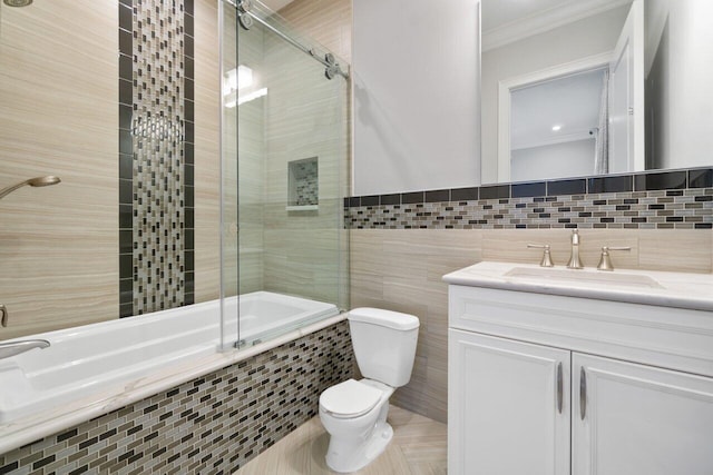 full bathroom with vanity, ornamental molding, tiled shower / bath combo, tile walls, and toilet
