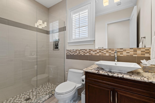 bathroom featuring visible vents, a shower stall, toilet, vanity, and tile walls