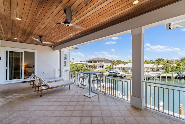 view of patio / terrace with a balcony, a water view, and ceiling fan