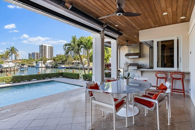 view of patio / terrace featuring a city view, a water view, area for grilling, and a ceiling fan
