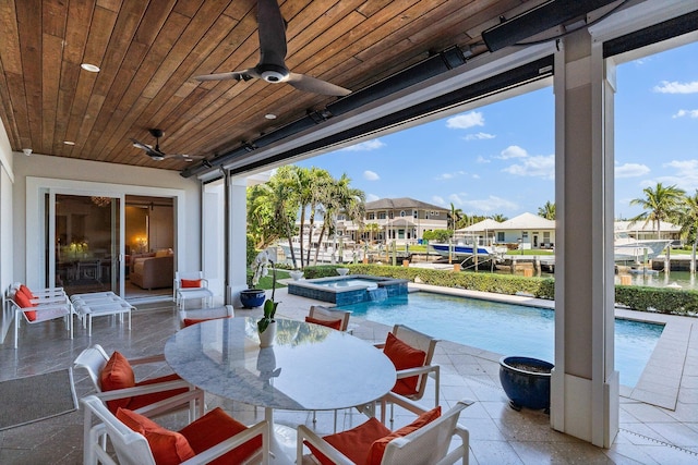 view of pool with a patio area, a residential view, a pool with connected hot tub, and ceiling fan