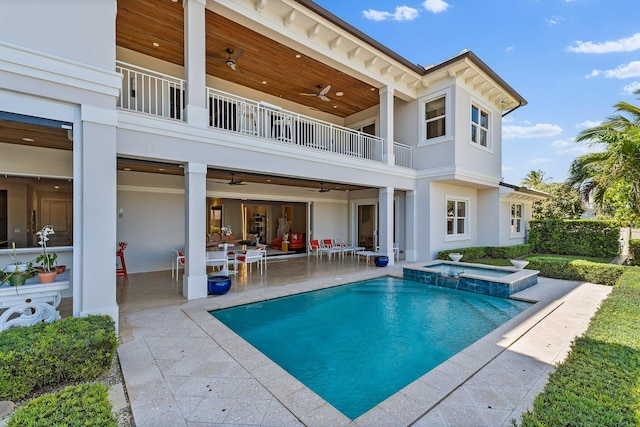back of house featuring a pool with connected hot tub, ceiling fan, stucco siding, a balcony, and a patio area