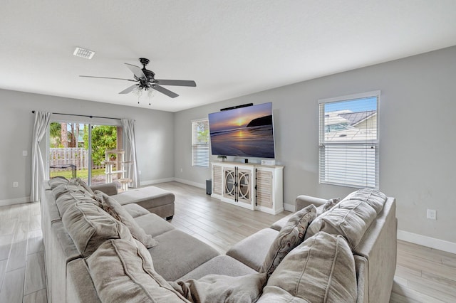 3558 SW Pisano St, Port Saint Lucie, FL 34953 - living room with ceiling fan, visible vents, baseboards, and light wood-style flooring