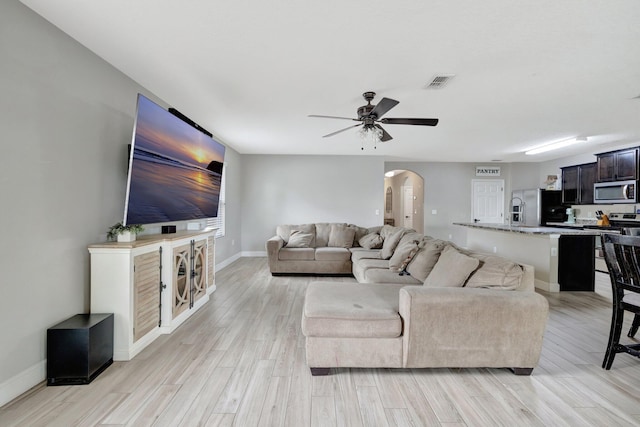 3558 SW Pisano St, Port Saint Lucie, FL 34953 - living area with a ceiling fan, visible vents, baseboards, light wood-style flooring, and arched walkways