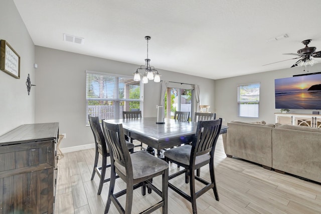 3558 SW Pisano St, Port Saint Lucie, FL 34953 - dining area with ceiling fan with notable chandelier, light wood-style floors, visible vents, and baseboards