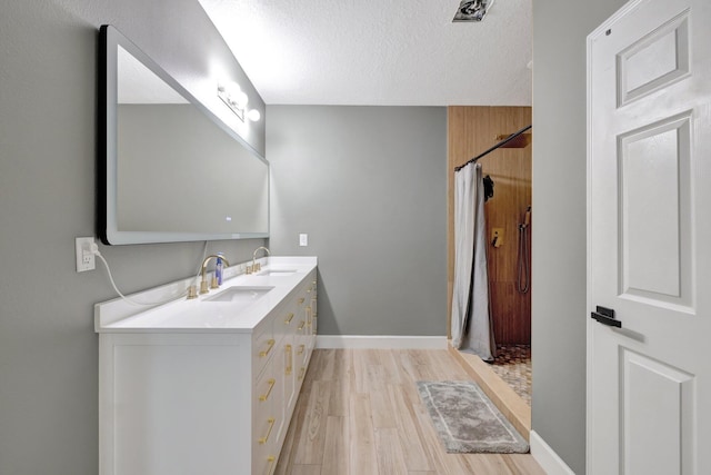 3558 SW Pisano St, Port Saint Lucie, FL 34953 - bathroom with double vanity, curtained shower, wood finished floors, and a sink