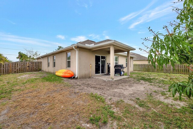 3558 SW Pisano St, Port Saint Lucie, FL 34953 - rear view of property with stucco siding, a fenced backyard, and a patio area
