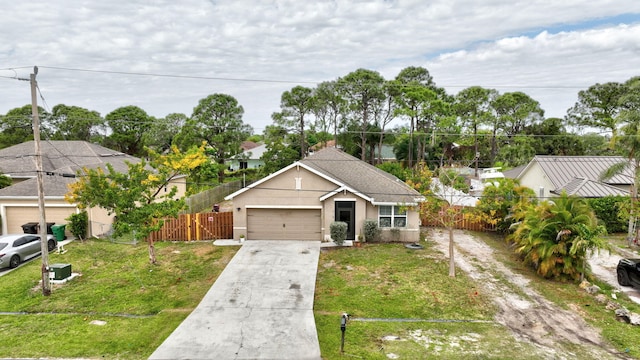 3558 SW Pisano St, Port Saint Lucie, FL 34953 - view of front of property with a front lawn, fence, concrete driveway, stucco siding, and a garage