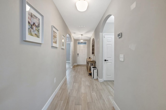 3558 SW Pisano St, Port Saint Lucie, FL 34953 - hall featuring baseboards, arched walkways, and light wood-style floors