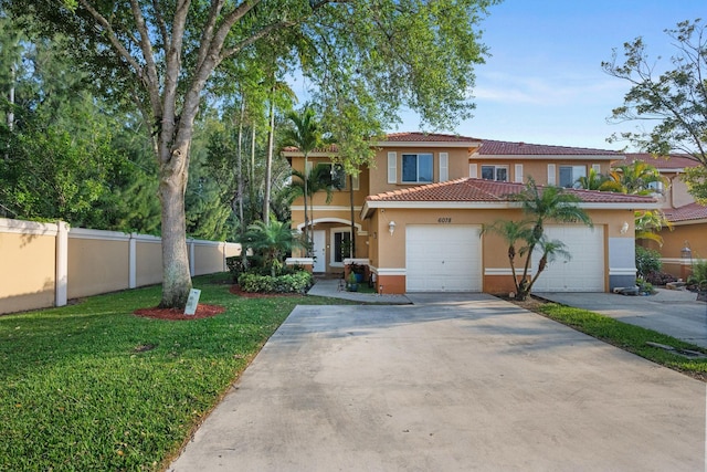 view of front of house featuring fence, a front yard, stucco siding, driveway, and an attached garage