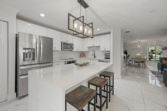 kitchen featuring marble finish floor, stainless steel appliances, light countertops, and a sink