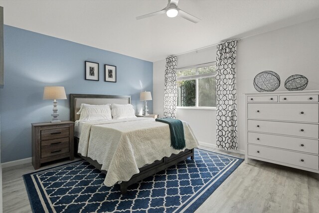bedroom with a ceiling fan, baseboards, and wood finished floors