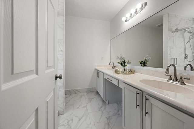 bathroom with double vanity, a stall shower, marble finish floor, and a sink