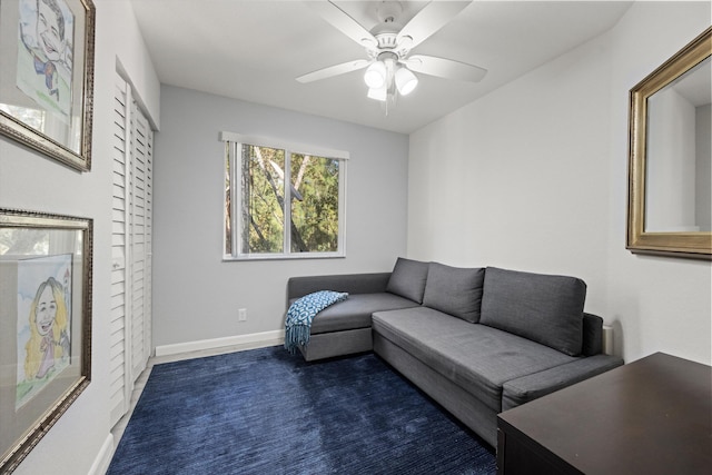 carpeted living room featuring baseboards and ceiling fan
