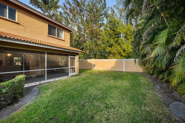 view of yard with a fenced backyard and a sunroom