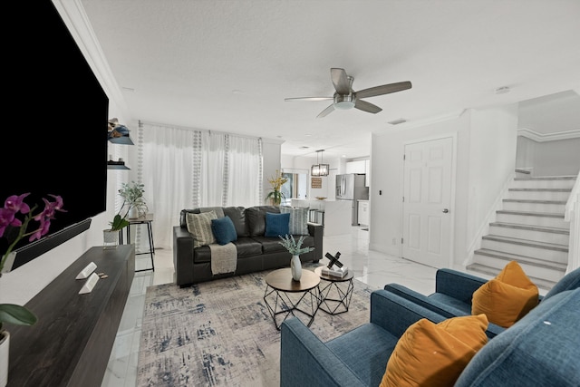 living room featuring a ceiling fan, marble finish floor, stairs, and crown molding