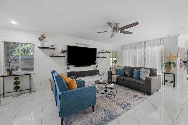living area featuring plenty of natural light, marble finish floor, crown molding, and a ceiling fan
