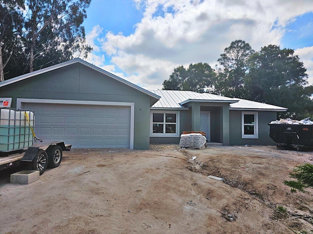 3897 NW 19th Ave, Okeechobee, FL 34972 - view of front of property with stucco siding, driveway, metal roof, and an attached garage