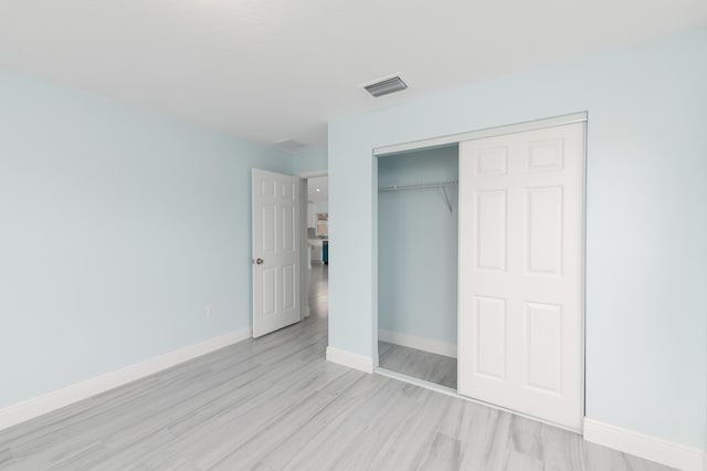 3897 NW 19th Ave, Okeechobee, FL 34972 - unfurnished bedroom featuring visible vents, a closet, light wood-style flooring, and baseboards