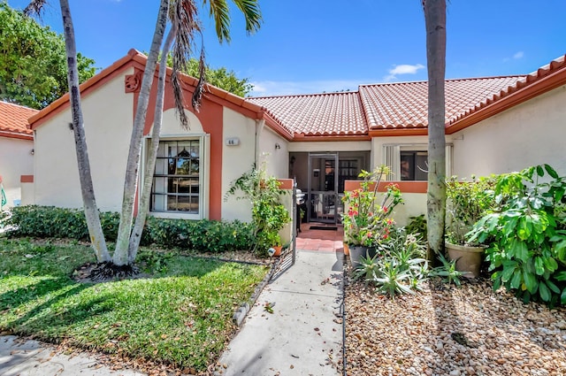 mediterranean / spanish-style house featuring a tiled roof and stucco siding