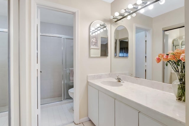 bathroom with tile patterned floors, toilet, a stall shower, and vanity