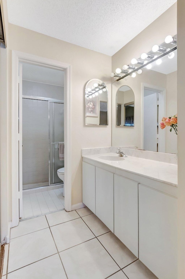 full bathroom with toilet, vanity, a stall shower, tile patterned floors, and a textured ceiling