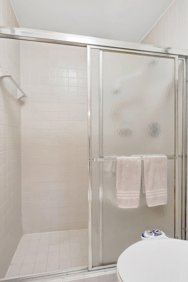 full bath with toilet, a stall shower, and vaulted ceiling