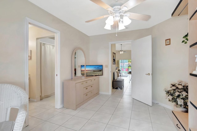bedroom with light tile patterned flooring, baseboards, and ceiling fan