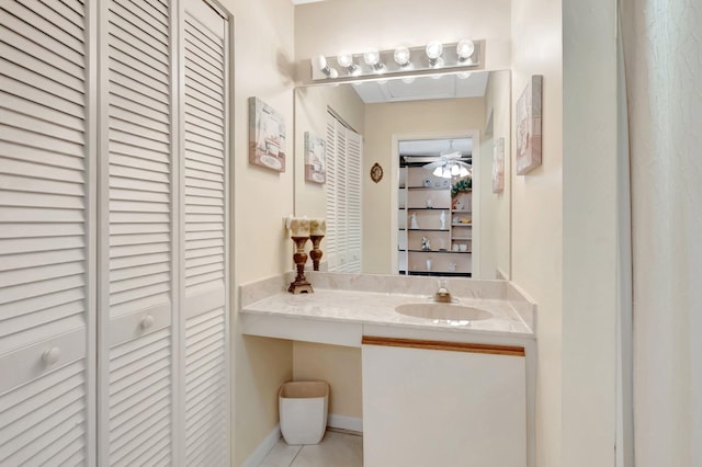 bathroom with tile patterned flooring, baseboards, a closet, and a sink