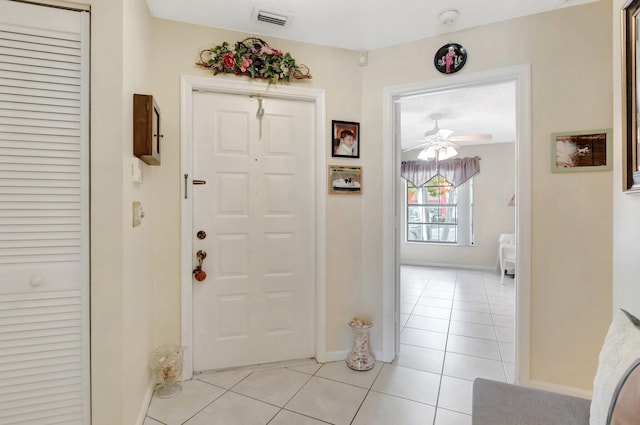foyer with visible vents, baseboards, light tile patterned flooring, and a ceiling fan