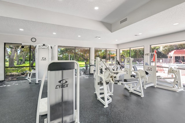 exercise room featuring visible vents, recessed lighting, and a textured ceiling