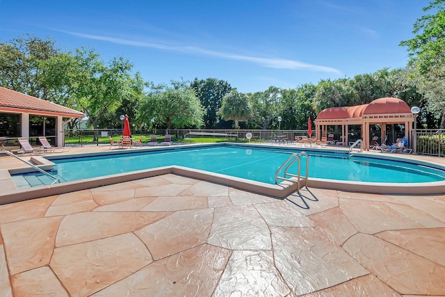 pool with a patio and fence