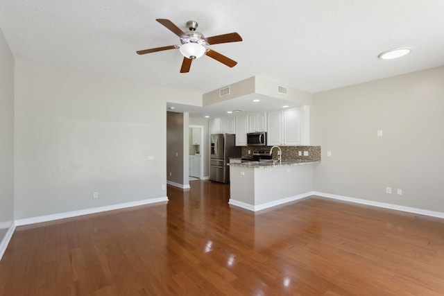 155 Waterford Dr, Jupiter, FL 33458 - kitchen with stainless steel appliances, a ceiling fan, a peninsula, white cabinets, and backsplash