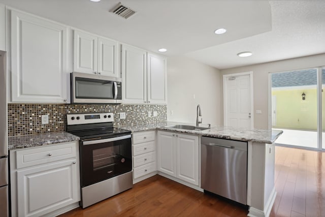 155 Waterford Dr, Jupiter, FL 33458 - kitchen featuring stainless steel appliances, a sink, dark wood-style floors, a peninsula, and backsplash