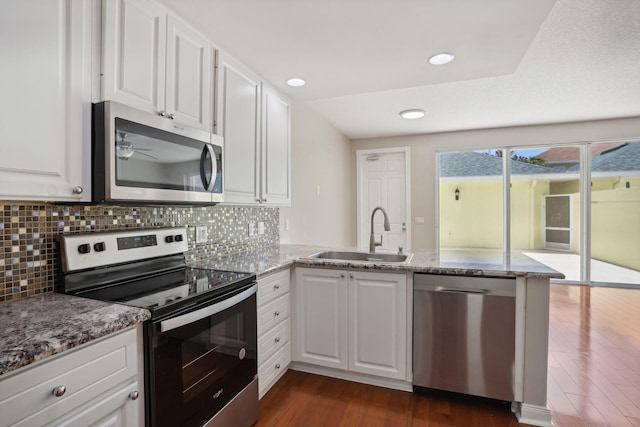 155 Waterford Dr, Jupiter, FL 33458 - kitchen with appliances with stainless steel finishes, a sink, dark wood finished floors, a peninsula, and tasteful backsplash