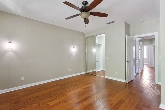 155 Waterford Dr, Jupiter, FL 33458 - unfurnished bedroom featuring wood finished floors, baseboards, ceiling fan, and a closet