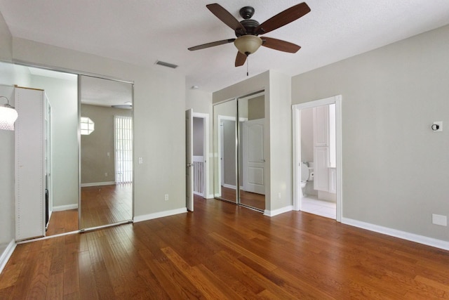 155 Waterford Dr, Jupiter, FL 33458 - unfurnished bedroom featuring multiple closets, wood finished floors, baseboards, and ceiling fan